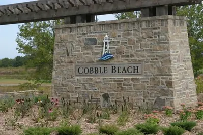 Paired limestone gate posts flanking a drive at Cobble Beach Golf Links