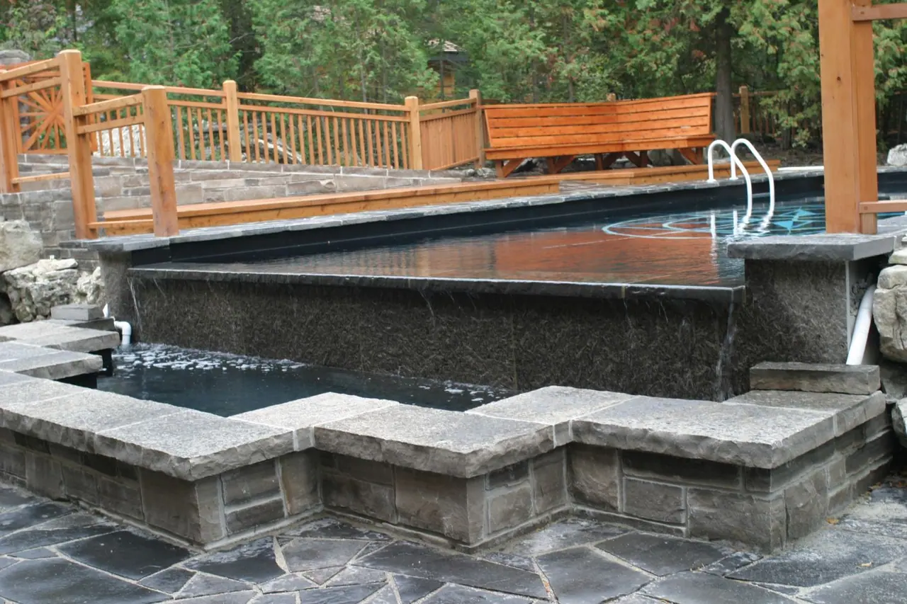 Limestone coping capping a coursed wall above random broken flagstone paving
