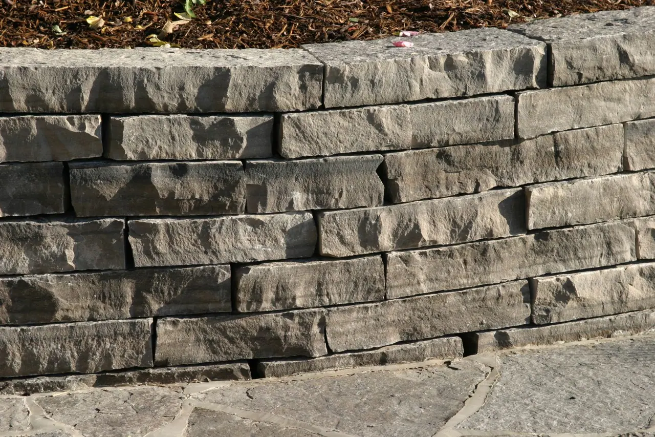 Guillotined limestone wall stone with broken ends in a garden wall
