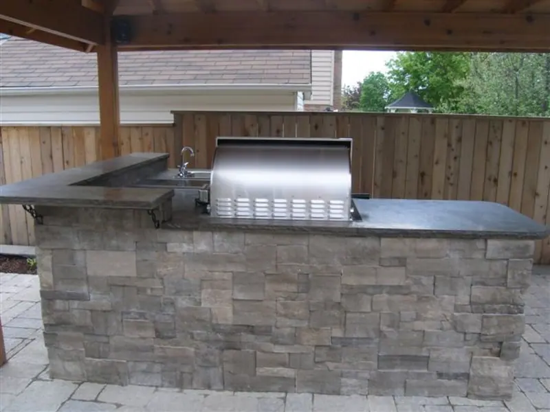 Limestone thin veneer cladding an outdoor kitchen island under a timber roof