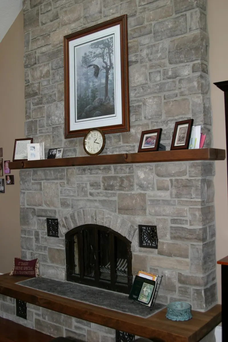 Floor to ceiling limestone thin veneer fireplace surround with a timber mantel